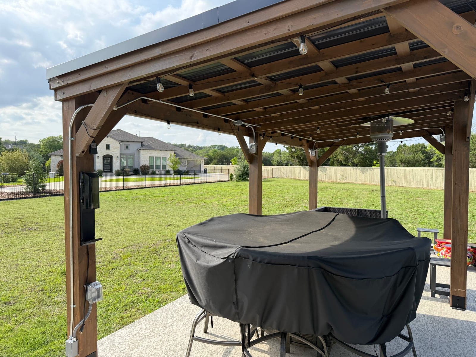 Backyard pergola with installed string lighting